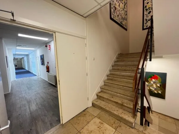 Trappenhuis en gang met kunstwerken aan de muur in een gebouw aan de Jan van Eycklaan.